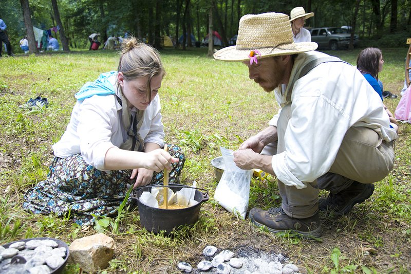 Whitney Way, left, and Jason Morriss check the batter for their Dutch-oven brownies at the Searcy Stake Trek. The trek took place along Lyons Creek outside Melbourne and simulated the exodus of Mormons from Illinois to Utah in the mid-1800s shortly after Joseph Smith’s assassination. 