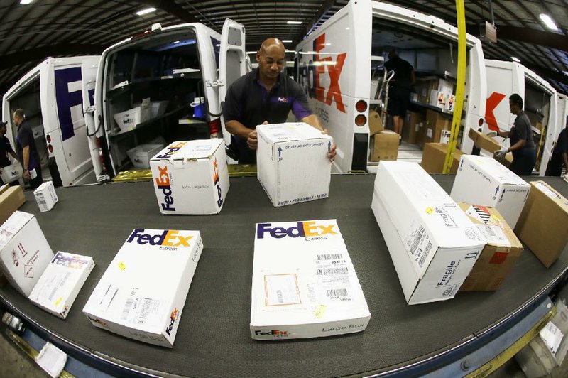 Workers load packages into delivery trucks last year at a FedEx Express station in Nashville, Tenn. The company on Wednesday reported a quarterly profit of $753 million, missing analyst estimates. 