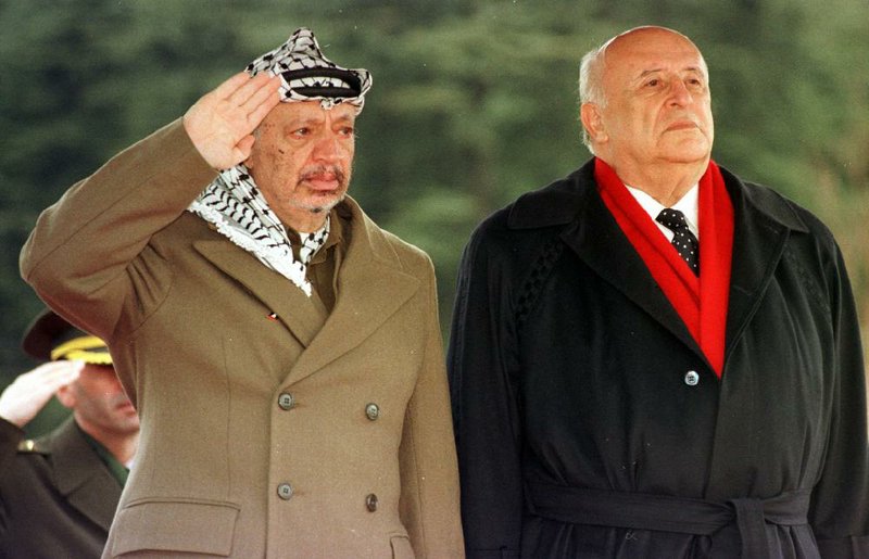 Then-Palestinian leader Yasser Arafat (left) and Turkish President Suleyman Demirel listen to their countries’ national anthems in this February 1991 photo in Ankara, Turkey. Officials at an Ankara hospital said Demirel has died.