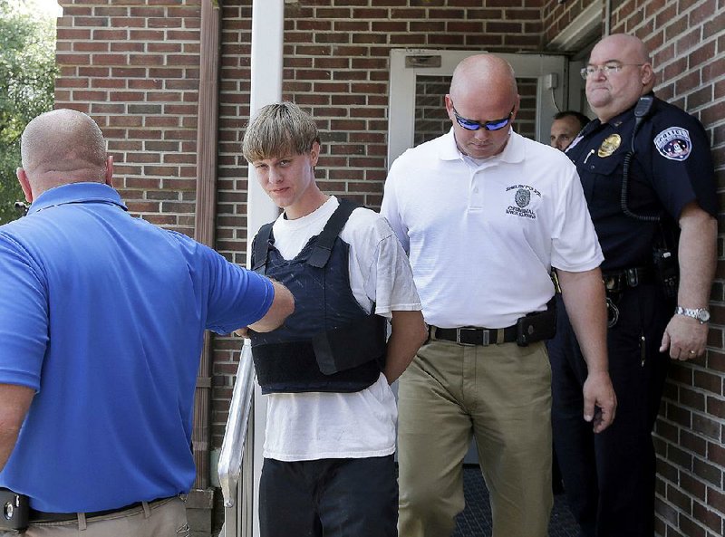 Charleston, S.C., shooting suspect Dylann Storm Roof is escorted Thursday from the Shelby Police Department in Shelby, N.C., where he was taken into custody. 