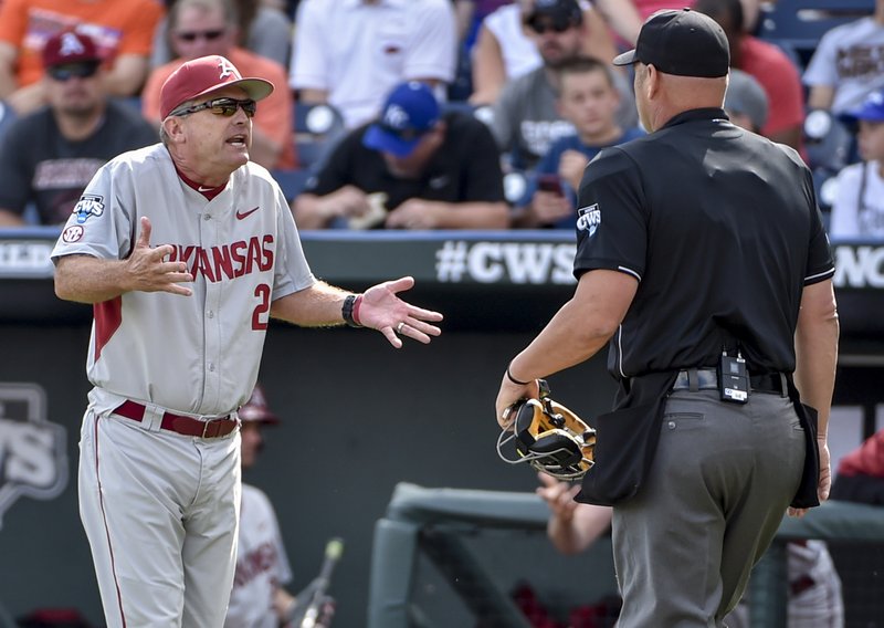 Arkansas coach Dave Van Horn, left, argues with home plate umpire Patrick Riley after Arkansas batter Clark Eagan was hit by a pitch in the second inning of an NCAA College World Series baseball tournament elimination game against Miami at TD Ameritrade Park in Omaha, Neb., Monday, June 15, 2015. (AP Photo/Mike Theiler)