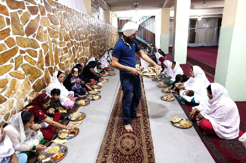 Afghan Sikhs eat in a langar, a free community kitchen, in a Gurdwara in Kabul. Many Sikhs are leaving the country to escape discrimination. 