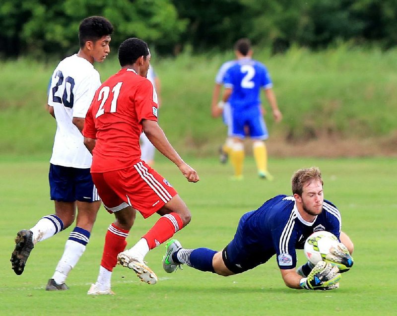 Arkansas Comets goalkeeper Benjamin O’Brien (right) makes a diving save in front of teammate Angel Herrea (20) and FC Dallas’ Darius Strambler (21) during Friday’s game in the U.S.Youth Soccer Region III Championships at Burns Park in North Little Rock. See more photos at arkansasonline.com/galleries.