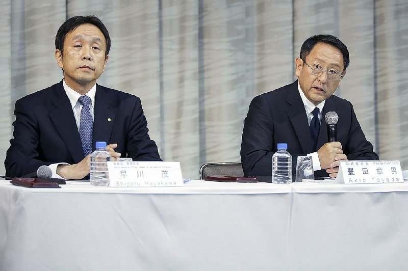 Shigeru Hayakawa, senior managing officer for Toyota Motor Corp. (left), sits with Akio Toyoda, president of Toyota Motor Corp., during a news conference in Tokyo on Friday. Toyoda said he’s confident the company’s first female executive, Julie Hamp, didn’t intentionally break Japanese law, a day after her arrest for allegedly importing a controlled drug. 
