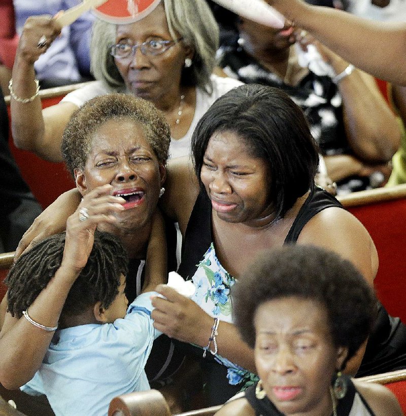 Parishioners pray and weep during services Sunday at the Emanuel AME Church in Charleston, S.C., four days after a mass shooting that claimed the lives of its pastor and eight others.