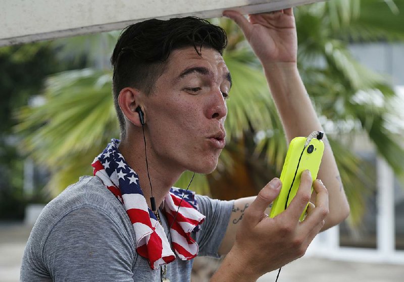 Adonis Ortiz chats on March 15 with his father, who lives in the United States, using a free Wi-Fi network at a center in Havana. Cuba says it's expanding Internet access by adding Wi-Fi capacity to dozens of state-run Internet centers and more than halving the cost that users pay for an hour online.