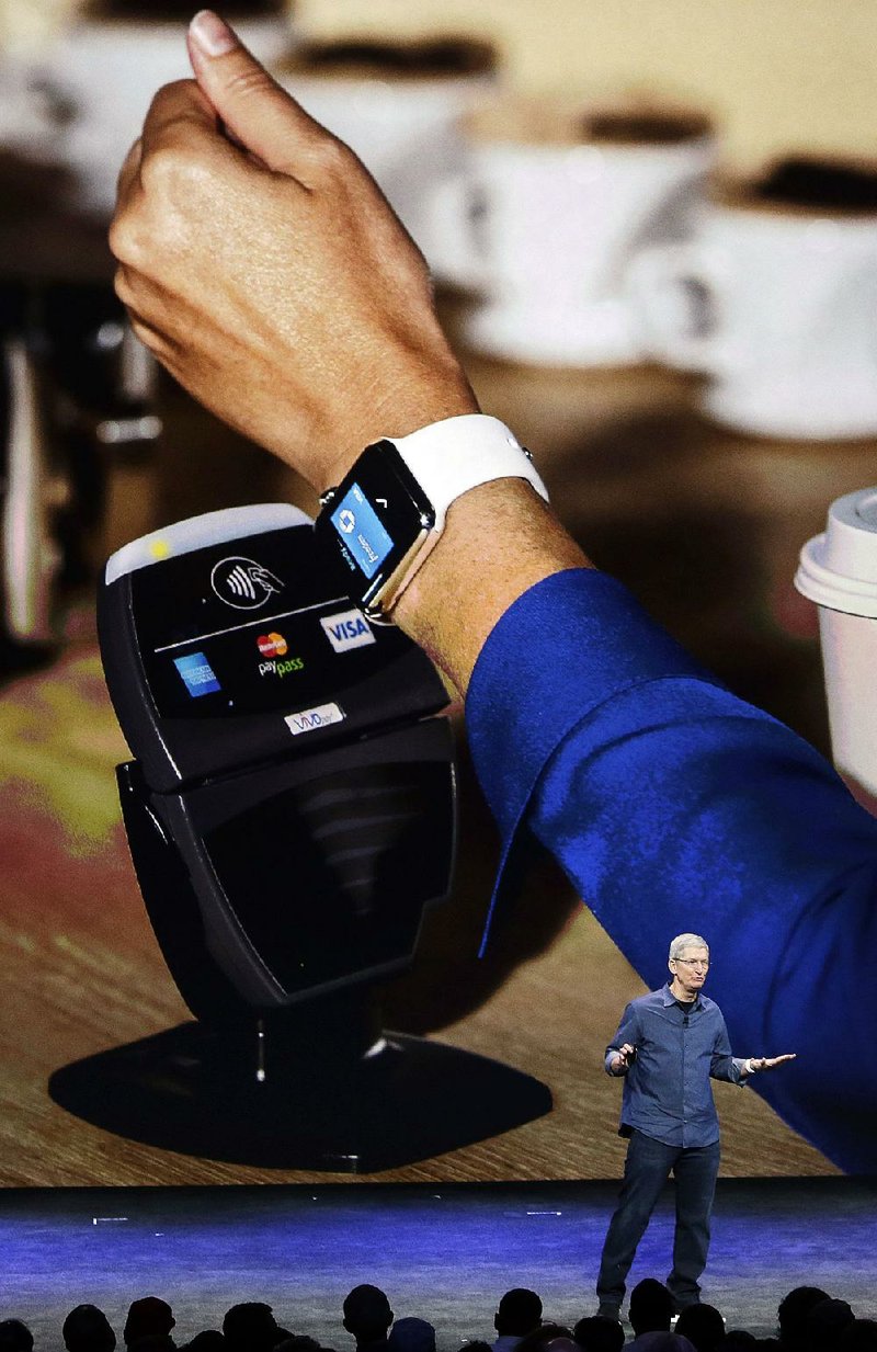 Apple CEO Tim Cook explains how the Apple Watch works in conjunction with Apple Pay during an announcement of new products in Cupertino, Calif., in September. On June 8, Apple said that it's adding store-issued credit cards and store rewards programs to Apple Pay, the mobile payments service it launched last fall.