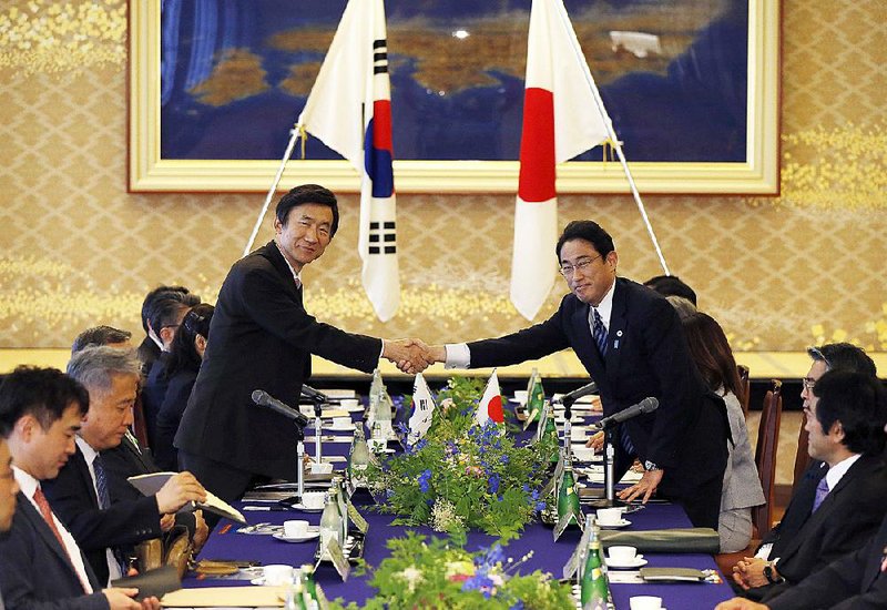 South Korea’s Foreign Minister Yun Byung-se (left) and Japan’s Foreign Minister Fumio Kishida share greetings before their meeting at the foreign ministry’s Iikura guesthouse in Tokyo on Sunday.