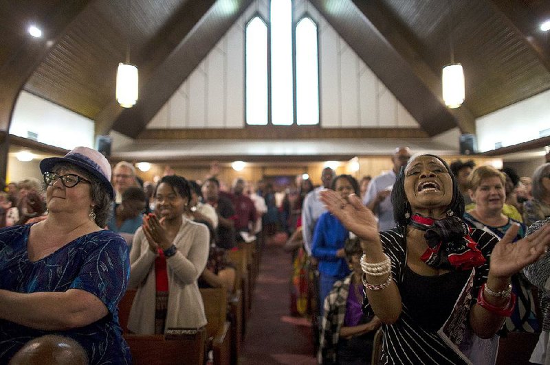 Visitors to Bethel African Methodist Episcopal Church in North Little Rock join in praise Sunday, singing “Amazing Grace.” The gathering, called a prayer vigil of remembrance, was hosted in memory of those killed at Emanuel AME Church in Charleston, S.C.