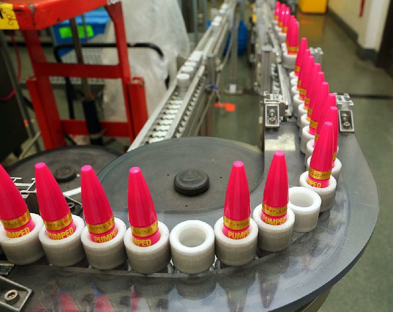 Containers of Pumped Up Volume mascara roll off an automated assembly line at Maybelline’s factory in North Little Rock, with empty spots left where ones that did not meet the company’s standards were rejected.