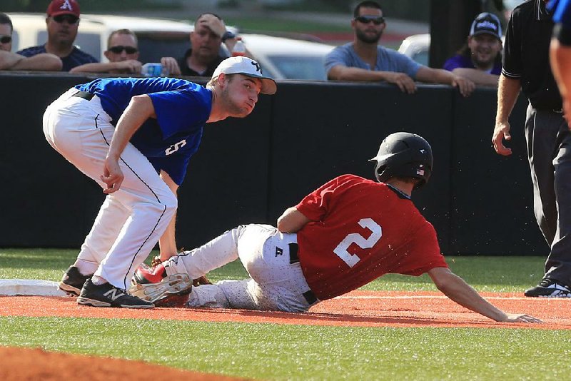 East third baseman John Beck (left) of Wonderview tags out Farmington’s Keaton Austin of the West during the first game of the All-Star baseball doubleheader Tuesday in Conway. 