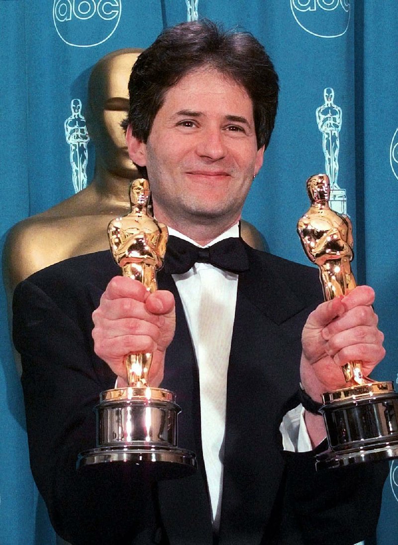 Composer James Horner shows the Oscars he won for Original Song and Original Dramatic Score for Titanic at the 70th Academy Awards in Los Angeles in this March 23, 1998, file photo. Horner, 61, died in a plane crash Monday.
