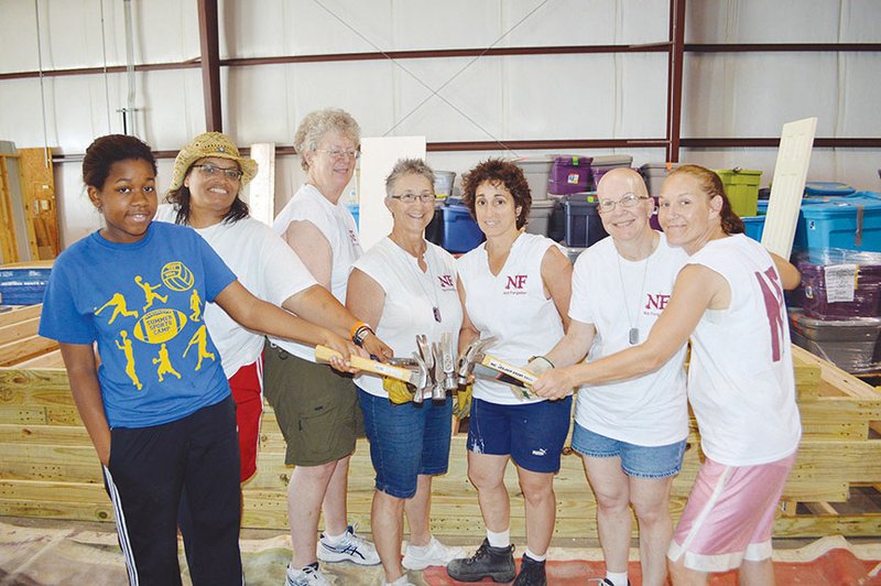 Carmen Richardson, a student at Conway High School, hammers a nail into a board at the Habitat for Humanity of Faulkner County warehouse in Conway. Richardson joined a group of out-of-state and local volunteers to build a house on Walnut Street, which is scheduled to be completed July 15. A Women Build 2015 is planned for the next home, which will be built on Pine Street.