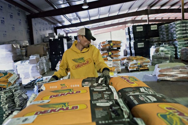 Bags of Monsanto Co. DeKalb brand seed corn are sorted in March at the Crop Protection Services facility in Manlius, Ill. Monsanto’s revenue rose 8 percent to $4.58 billion in the third quarter, the reported Wednesday. 