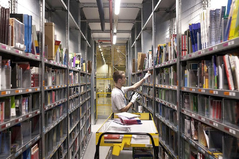An Amazon.com employee uses a scanner earlier this month while restocking shelves at a warehouse in Poznan, Poland. Amazon is one of many companies with shares trading at more than $100.  