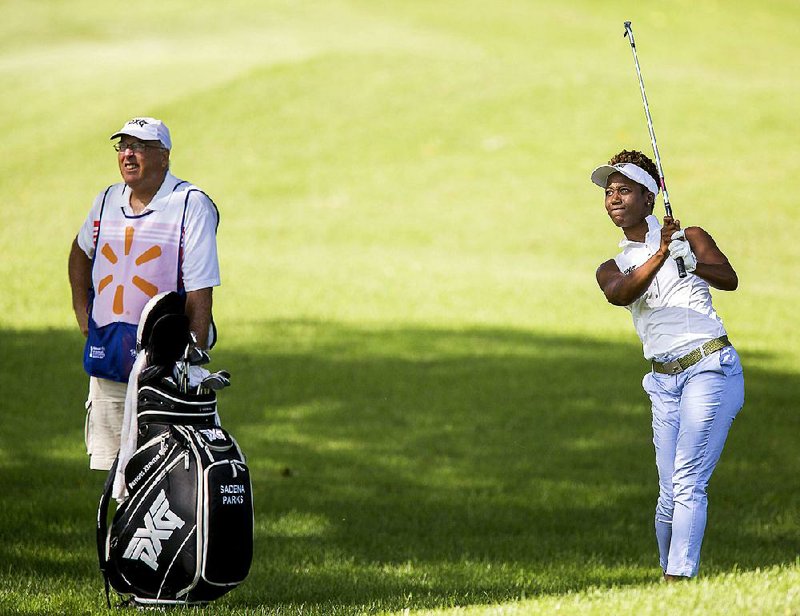 Sadena Parks (right) of Spanaway, Wash., hits an approach shot from the No. 8 fairway during Wednesday’s pro-am.