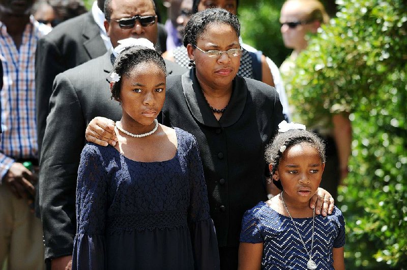 Jennifer Pinckney and her daughters, Eliana (left) and Malana, follow the coffin of state Sen. Clementa Pinckney into the South Carolina Statehouse in Columbia on Wednesday, where Pinckney’s open coffin was put on display in the rotunda.