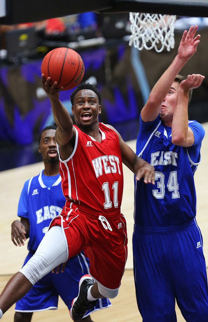 The West’s Tereke Eckwood of Springdale Har-Ber (11) drives past the East’s Sam Dunkum of North Little Rock (34) during the Arkansas High School Coaches Association All-Star boys basketball game Thursday night at the Farris Center in Conway. Eckwood finished with six points.