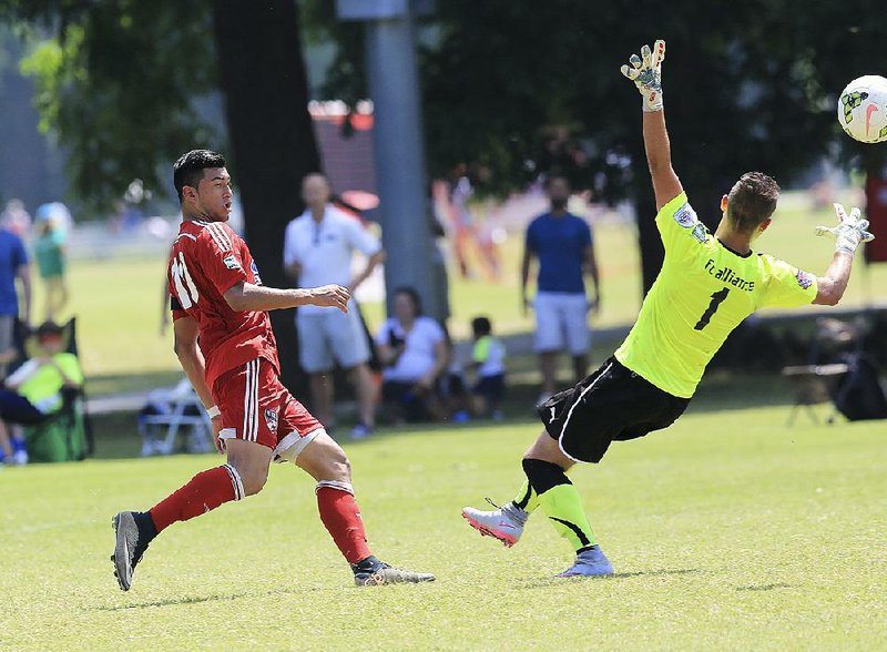 FC Dallas 98 Premier’s Gerber Chavez kicks past FC Alliance 98 Black goalie Stephen Wise to score his second goal in the fi rst half of the boys under-17 fi nal Thursday in the U.S.Youth Soccer Region III Championships at Burns Park in North Little Rock. Dallas won 3-1. More photos at arkansasonline.com/galleries. 