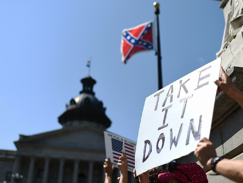 Protesters hold a sign during a rally to take down the Confederate flag at the South Carolina Statehouse, Tuesday, June 23, 2015, in Columbia, S.C. 