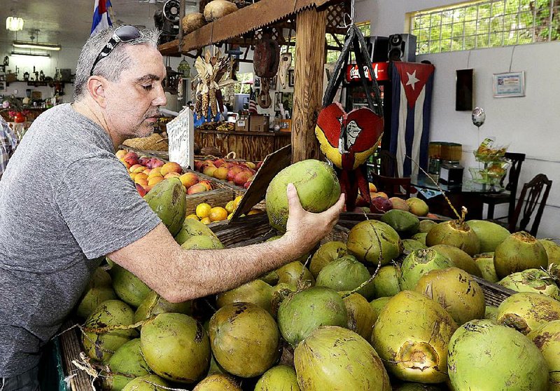 A customer shops for coconuts at a stand in the Little Havana area of Miami earlier this month. Consumer spending rose 0.9 percent in May, the Commerce Department said Thursday. 