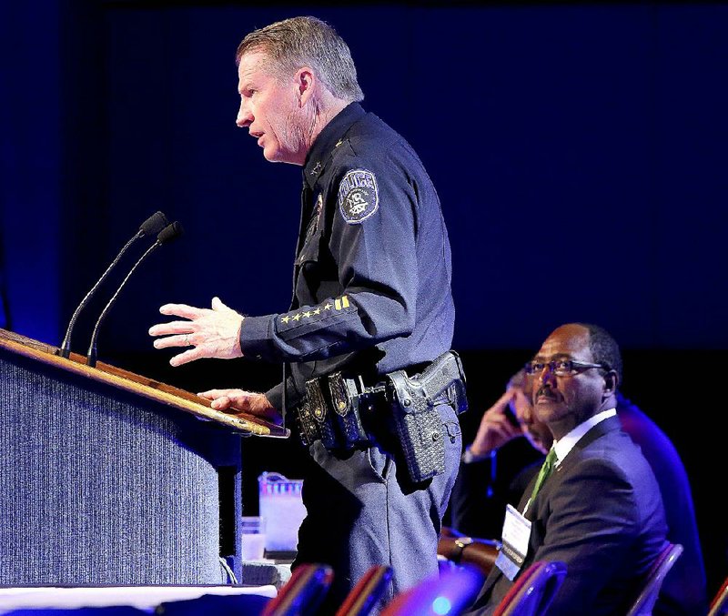 North Little Rock Police Chief Mike Davis speaks during the Arkansas Municipal League Convention on Thursday at the Statehouse Convention Center in Little Rock. At right is Blytheville Mayor James Sanders. 