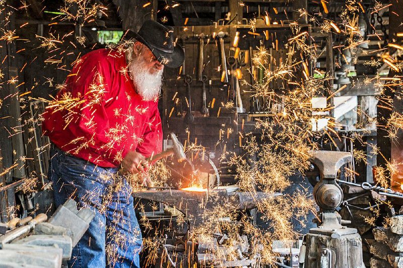 A blacksmith pounds metal during a demonstration at Silver Dollar City, an 1880s theme amusement park. The park has 100 craftsmen and dozens of demonstrations. 