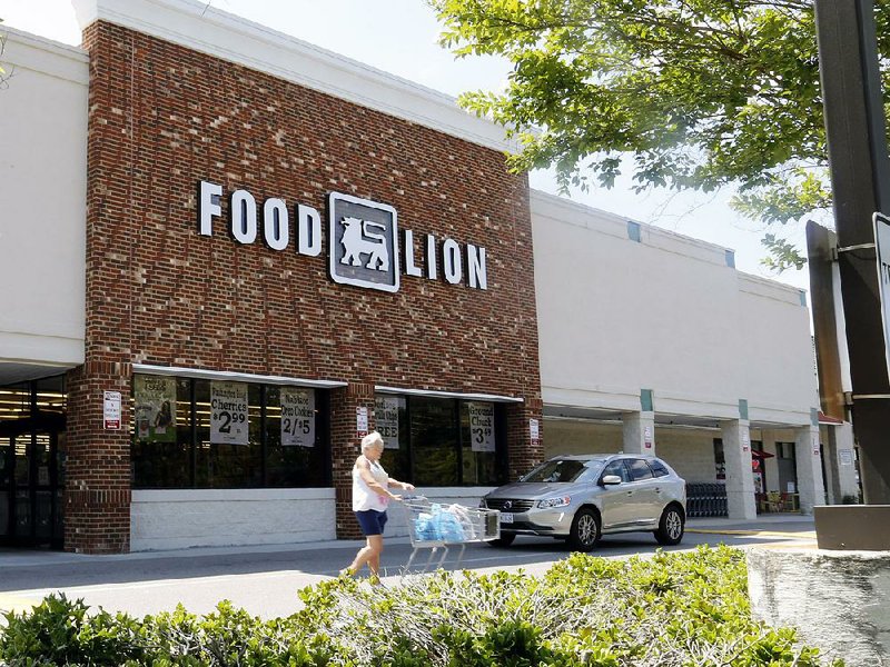 A shopper heads out of a Food Lion store in Richmond, Va., Wednesday, June 24, 2015. Dutch retailer Royal Ahold NV, which operates U.S. supermarket chains Stop & Shop and Giant, has agreed to merge with its Belgian counterpart Delhaize Group, which operates the Hannaford and Food Lion stores in the eastern United States. (AP Photo/Steve Helber)