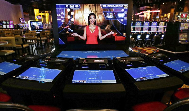 An automated dealer asks for players to take a seat at a blackjack video machine on the floor of the Plainridge Park Casino in Plainville, Mass. The casino represents the first gambling destination to open since state lawmakers approved a casino law in 2011. 
