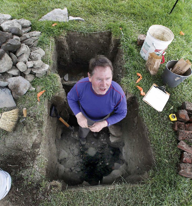 Michael O’Connor, curator of the Enfield Shaker Museum and volunteer archaeologist, stands in a pit searching for artifacts of the Shaker village in New Hampshire. 