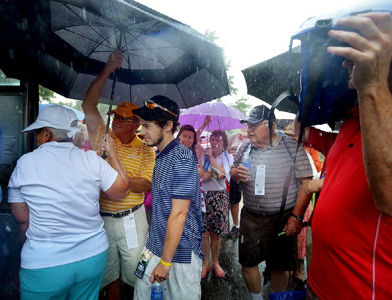 Spectators board a bus headed back to the John Q. Hammons Center in Rogers on Friday as lightning and rain forced a second postponement at Pinnacle Country Club in Rogers. Weather delays during the opening round totaled four hours. When play was suspended at 8:38 p.m., 63 players were still on the course. They will complete their rounds this morning.