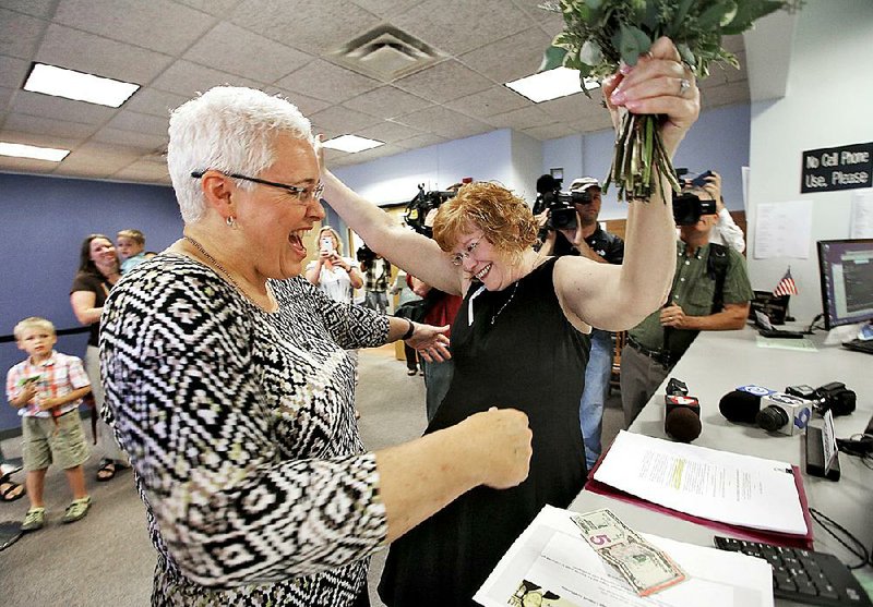 Mindy Ross (left) and Jimmie Beall celebrate Friday after paying to receive a marriage license in Probate Court in Columbus, Ohio. 