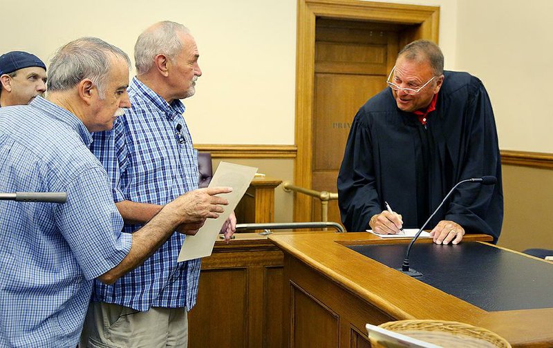 Tony Chiaro (left) and Earnie Matheson became the first gay couple to request a marriage license Friday at the Pulaski County Courthouse in Little Rock after same-sex marriage was ruled legal nationwide. Judge Chris Piazza (right) officiated. 