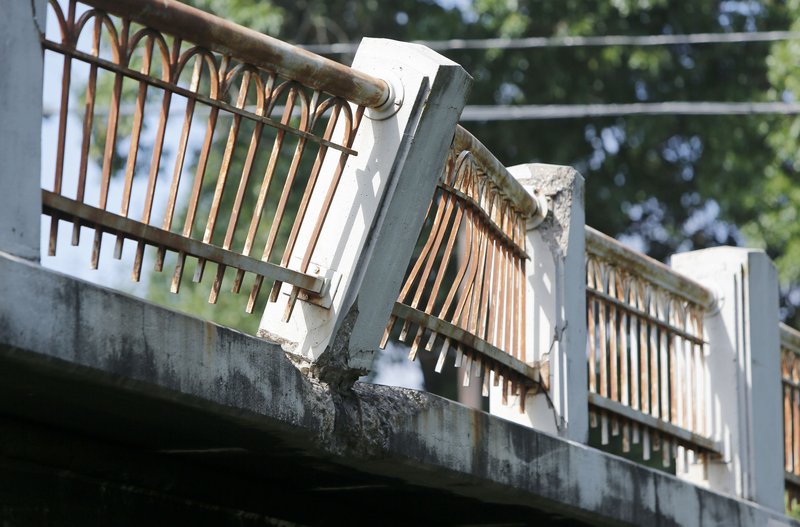 A portion of the railing is damaged on the Lafayette Street Bridge west of West Avenue in Fayetteville. City officials on Friday received just one construction bid for the restoration of the bridges on Lafayette and Maple streets, and the bid, from Sweetser Construction of Fayetteville, was more than double engineers’ estimates for the project.