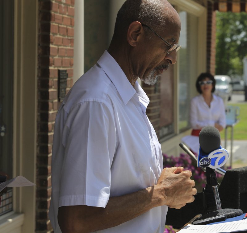 Arkansas Democrat-Gazette/STATON BREIDENTHAL Dale Charles (left), president of Arkansas NAACP, speaks Friday afternoon at a news conference in Little Rock where he called for Arkansas Flag and Banner owner Kerry McCoy (background right) to quit selling Confederate battle flags.