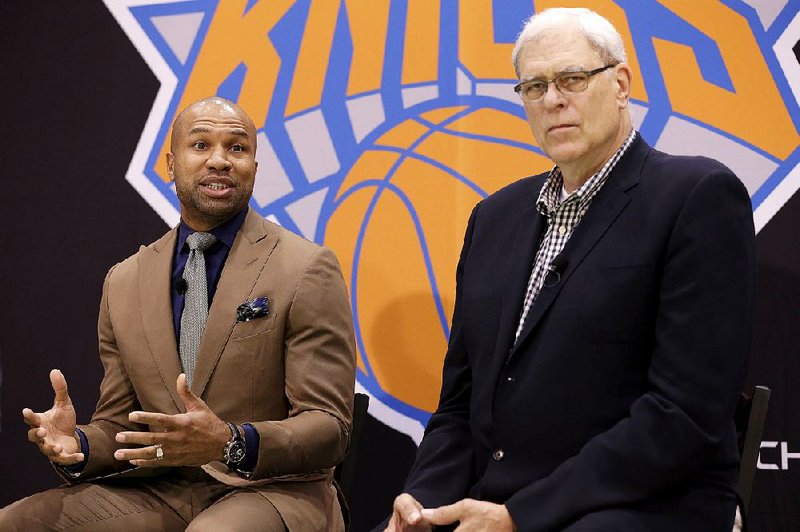 Derek Fisher (left) speaks in Tarrytown, N.Y., in this June 2014 file photo while New York Knicks president Phil Jackson listens.