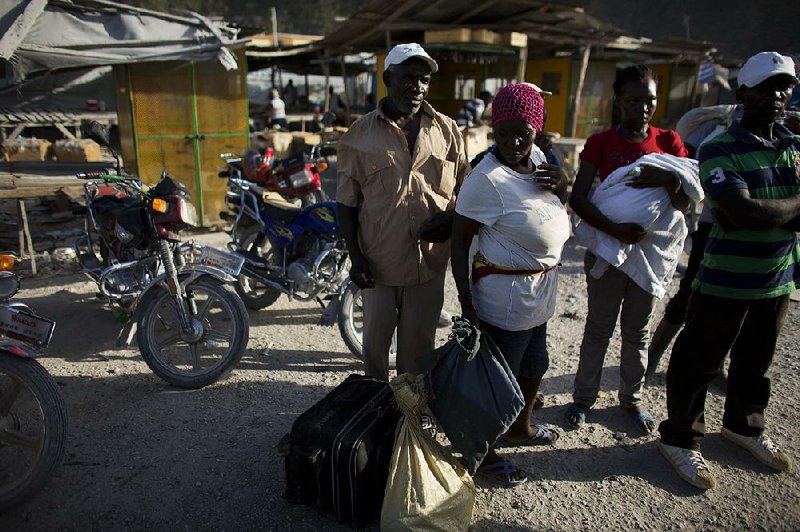 Haitian migrants just deported from Dominican Republic stand on the Haitian side of the border unsure what to do next, in Malpasse, Haiti, Wednesday, June 17, 2015. Authorities are prepared to resume deporting non-citizens without legal residency in the Dominican Republic after largely putting the practice on hold for a year, the head of the country's immigration agency said Tuesday. For decades, the Dominican Republic has deported non-citizens, the vast majority of whom come from neighboring Haiti to work in low-wage jobs.(AP Photo/Rebecca Blackwell)