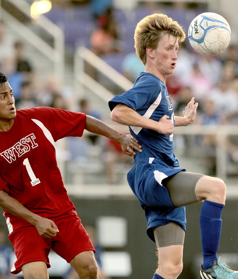 Benjamin Krain/Arkansas Democrat-Gazette East All-Star James Pollard, from Siloam Springs, right, and West All-Star Alex Tobar, from Hot Springs, battle for the ball during the Arkansas High School Coaches Association Boys All-Star Soccer game in Conway on Wednesday night.