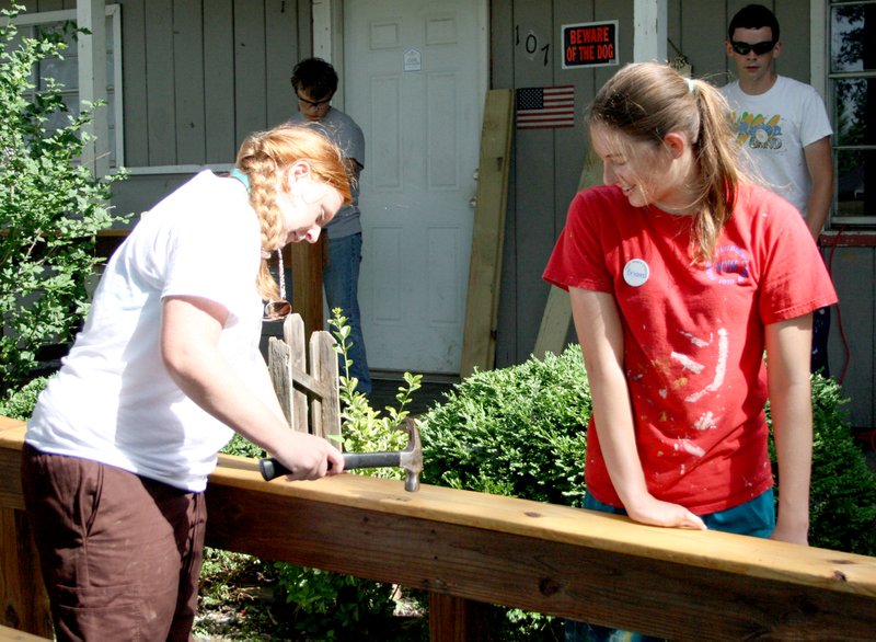 Rebecca Watkins (left) and Briana McClain are having a good time while improving the handrails on a wheelchair ramp that was originally constructed by OMP campers in 2012.