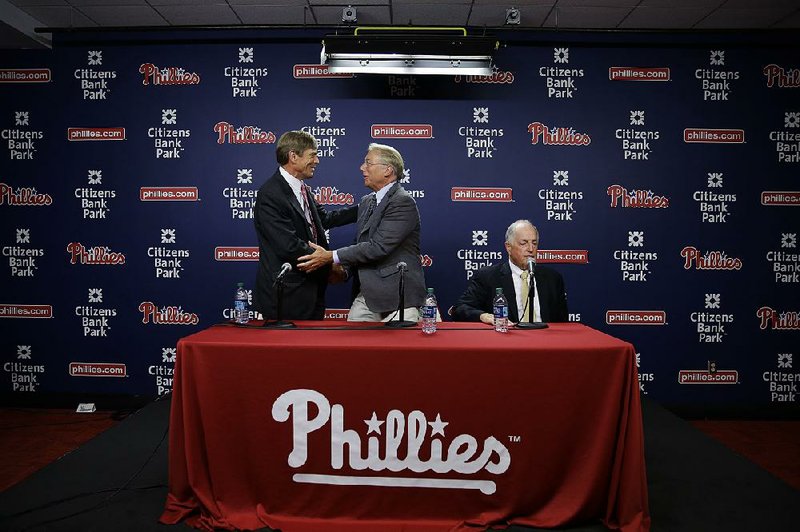Andy MacPhail (right) shakes hands with Philadelphia Phillies part-owner John Middleton after a news conference Monday in Philadelphia.
