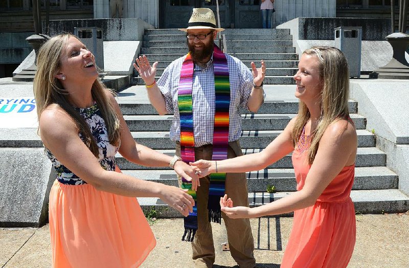 Tiffany Brosh (left) and Laurin Locke of Pearl, Miss., became the fi rst legally married same-sex couple in the Jackson metro area after a ceremony Monday that was officiated by Justin McCreary of the Unitarian Universalist Church of Jackson outside the Hinds County Courthouse.