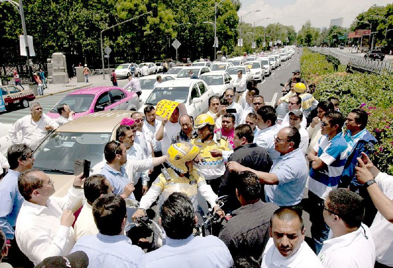 Taxi drivers scuffle with police in Mexico City last month as the drivers attempted to block a highway during a protest against ride-hailing service Uber.