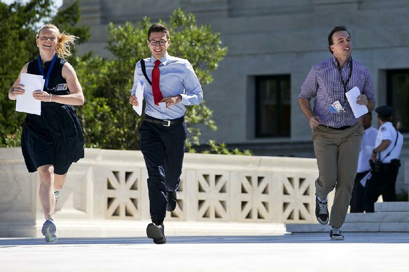 Interns for news outlets run Monday with a decision across the plaza of the Supreme Court in Washington. The court ruled against an Environmental Protection Agency regulation that would force old coal plants to close or clean up emissions.