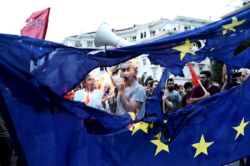 Members of leftist parties burn a European Union flag during a protest in the northern Greek port city of Thessaloniki on Sunday.