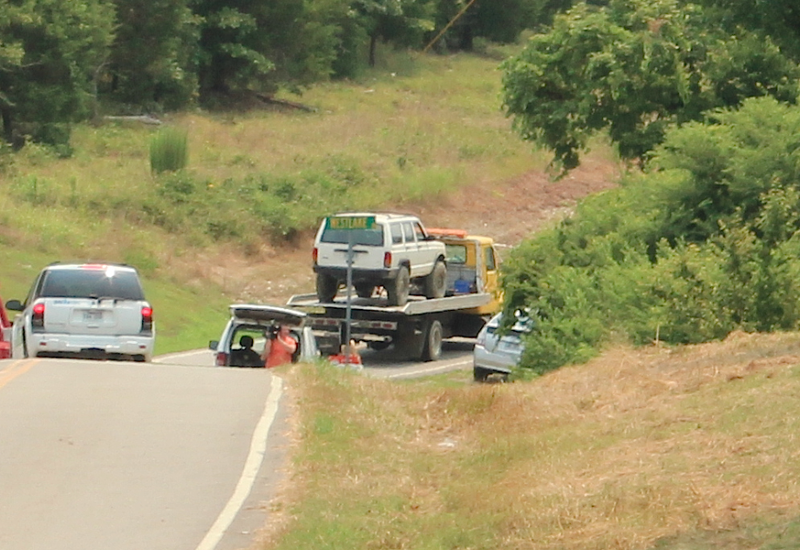 A Jeep Cherokee is towed from the Lake Norrell area Tuesday afternoon. Police found the driver and his 8-year-old son dead inside the partially submerged vehicle earlier in the day.