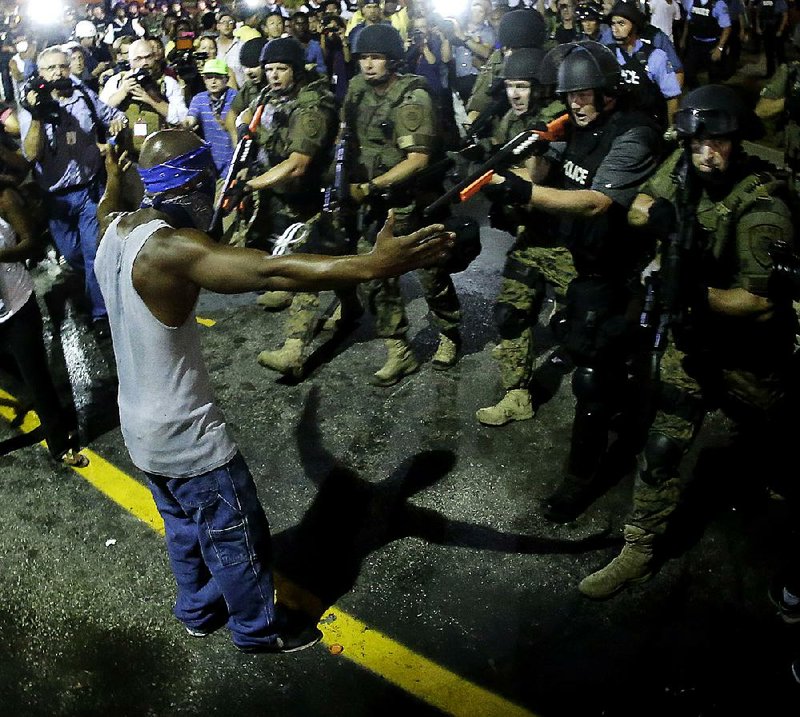 Police arrest a man as they disperse a protest in Ferguson, Mo., in this file photo from Aug. 9.