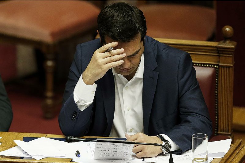 In this file photo dated Friday, June 5, 2015, Greece's Prime Minister Alexis Tsipras checks his notes during an emergency Parliament session in Athens.  