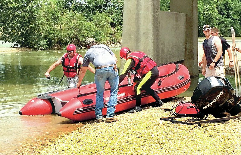NWA Democrat-Gazette/LANDON REEVES Members of the Siloam Springs Fire Department&#8217;s swift-water rescue team prepare to search the Illinois River for a man believed drown Tuesday at the Arkansas 59 Bridge near Siloam Springs. &#8220;We were setting up the tent and I heard them screaming for help,&#8221; said Jeremie Grant, who was camping by the river during the incident. &#8220;When I went down there, they said their uncle had went under and I never did see him after that, so I called 911.&#8221;