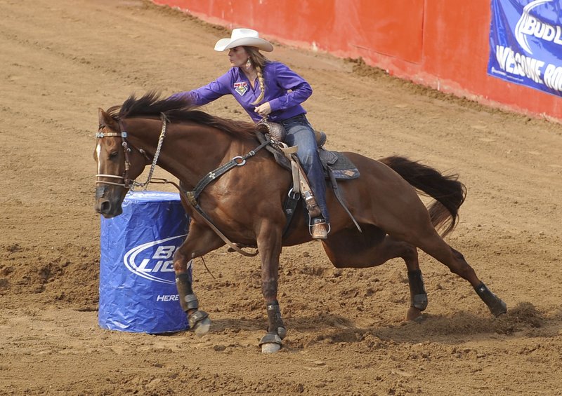 Barrel racer Amber Arnold rounds the first barrel during the go round Tuesday evening at the Rodeo of the Ozarks in Springdale.