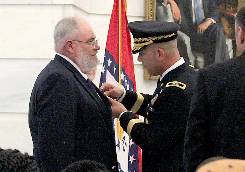 U.S. Army Maj. Gen. Jeffrey Snow pins a Purple Heart for slain soldier Pvt. William Long on Long's father, Daris Long, during a ceremony Wednesday, July 1, 2015.